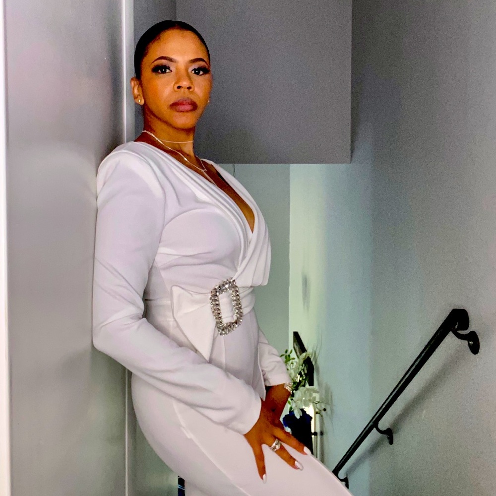 White Jumpsuit with a rhinestone belt and shoulder pads.